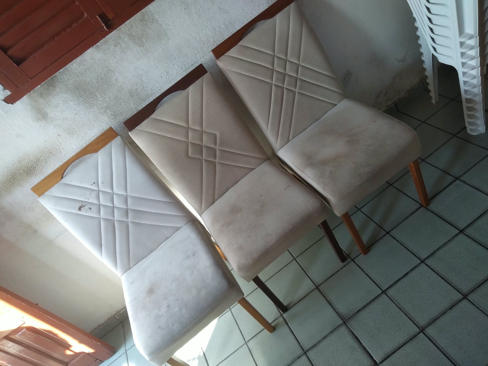 Três cadeiras de jantar manchadas antes da higienização