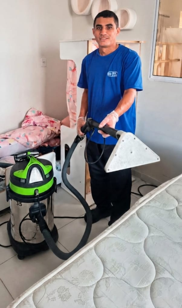 Josinildo de Santana higienizando um colchão com equipamento de extração